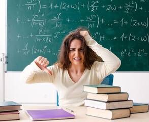Young female math teacher in front of chalkboard