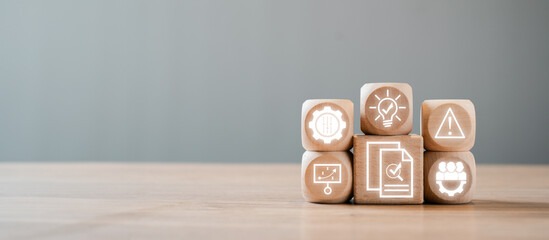Wooden blocks with icons representing audit concepts such as compliance, risk management, and business analysis on a wooden table.