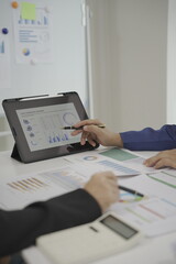 Close-up of business people discussing project plans and financial results in a business presentation meeting or seminar. Documents include financial or marketing figures, graphs and charts.