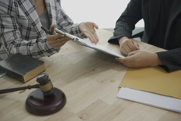 Businessman and lawyer discussing contract documents sitting at advice table legal services legal advisor Business dispute service at the office with fairness and hammer Close-up pictures