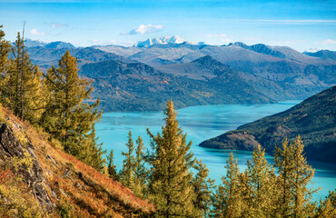 The view of the Kanas Lake in the autumn with the Friendship Peak in the distance in Xinjiang, China