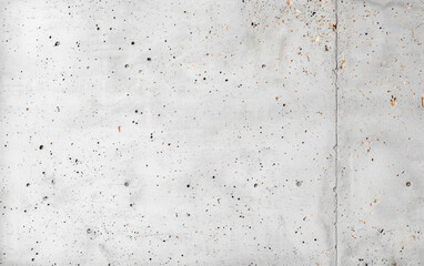 A close-up of a rough and weathered concrete wall surface, showcasing texture, small holes, and imperfections, perfect for backgrounds and design projects.