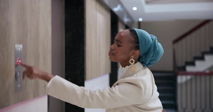 Business, woman and waiting for button by elevator for activating or lift usage and request floor in office building. Female person, worker and late in morning by workplace for management career.