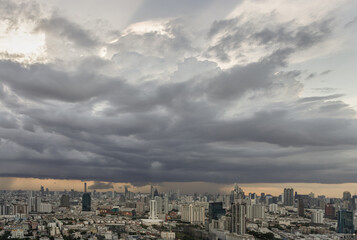 Obraz premium Aerial view of skyscrapers and dramatic sky before sunset. Beautiful clouds in the sky over large metropolitan city of bangkok, Copy space, Selective focus.