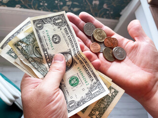 dollar and coins hold by hand