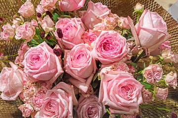 bouquet of fresh pink roses wrapped in craft paper. Holiday view from above
