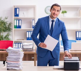 Young male employee making copies at copying machine