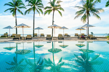 Beautiful umbrella and chair around swimming pool in hotel and resort