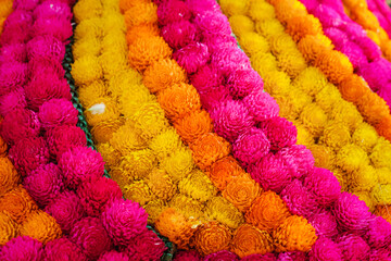 A colorful arrangement of flowers with pink, yellow, and orange petals. The flowers are arranged in...