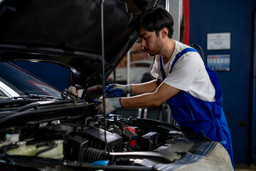 Obraz premium Professional Auto Mechanic Performing Vehicle Inspection and Maintenance in a Modern Garage