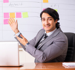 Young handsome employee working in the office