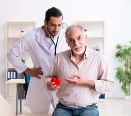 Old man visiting young male doctor cardiologist