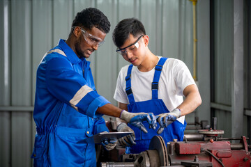 Professional Auto Mechanics Inspecting Vehicle Parts in a Modern Garage Using Digital Tablet for Maintenance and Repair