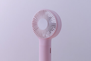 Close-up of modern portable handheld fan with minimalist design on white background