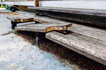 The wooden steps were broken at the joints of the planks. Old broken wooden stairs. Ladder made of wood broke at home. Damaged wooden stepladder. fungus decay on old wooden stair, effects of dampness.