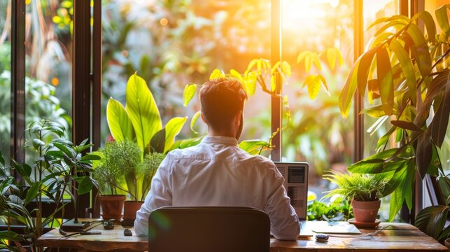A man works from home with a view of nature outside an open window. The concept of remote work, freelancing