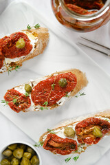 Overhead close-up view of bruschetta with sun-dried tomatoes and capers