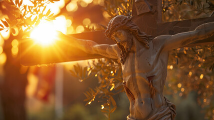 A sculpture of Jesus Christ on the cross, set against a serene evening sky