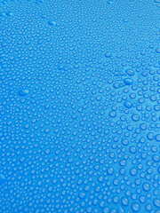 Water drops on blue background texture. backdrop glass covered with drops of water. Bubbles in water