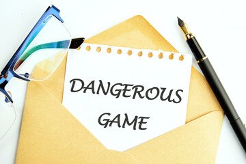 Text Dangerous game on a piece of paper sticking out of a postal envelope