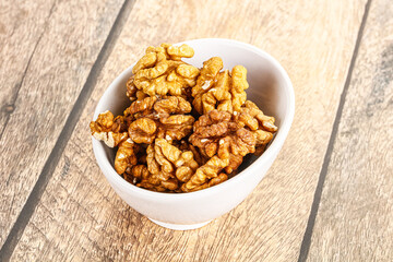 Cracked unshelled walnut in the bowl