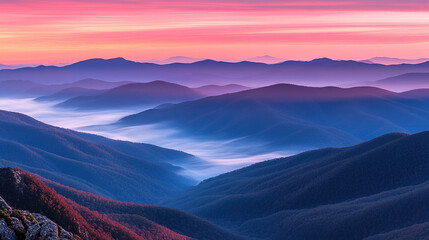 Breathtaking Sunrise Over Mountain Range with Pink and Orange Sky, Mist Gently Covering Valleys Below, Capturing the Serenity of Nature