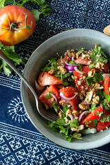bowl of salad with tomatoes and walnuts on the table, Georgian cuisine