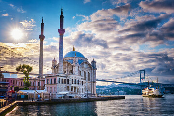Ortakoy Mosque against the backdrop of the city near the Bosphorus Bridge on a summer sunny day with clouds