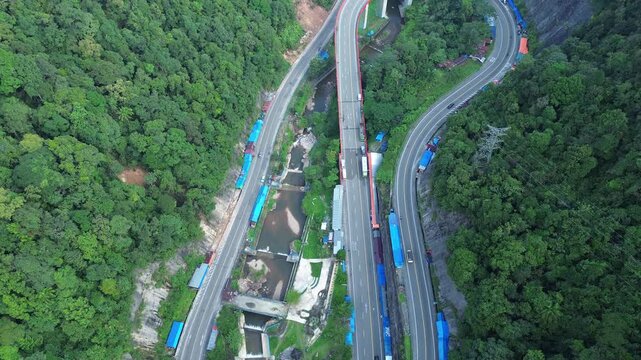 Payakumbuh, Indonesia - June 24, 2024: Stunning aerial drone views of Kelok 9, a scenic serpentine road in West Sumatra, showcasing its dramatic curves and lush surrounding landscapes. Perfect for tra