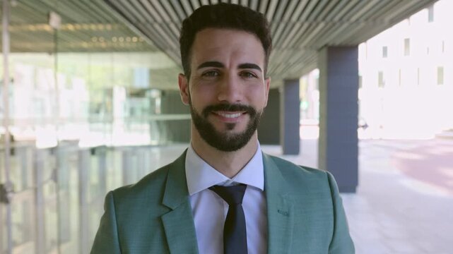 Confident portrait of handsome businessman walking towards the camera. Successful smiling adult man in suit looking at camera. Business and people concept
