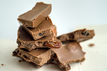 Pieces of chocolate laying on top of each other on white background.