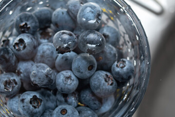 American blueberries in a transparent glass with water. Washing berries. Healthy eating. Vitamins.