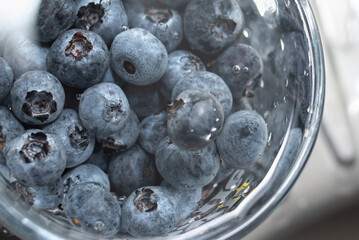 American blueberries in a transparent glass with water. Washing berries. Healthy eating. Vitamins.