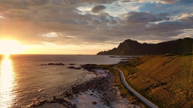 Eine wundersch&ouml;ne K&uuml;stenlandscahft auf der Insel And&oslash;ya in Norwegen leuchtet bei Mitternachtssonne in wundersch&ouml;nen warmen Farbt&ouml;nen
