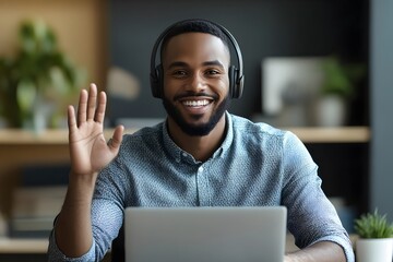 businessman wears headset smilingly talks to a video call on a laptop with waving hand. businessman connecting virtually with clients. virtual meetings, customer support
