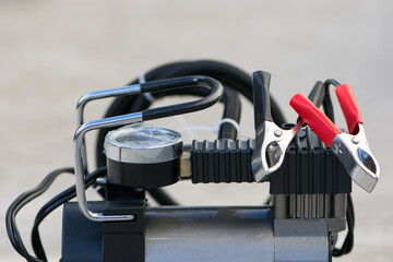 pump compressor for inflating car wheels close-up. Car pump in a black case on a gray background. the pump to inflate automobile wheels lying on the floor