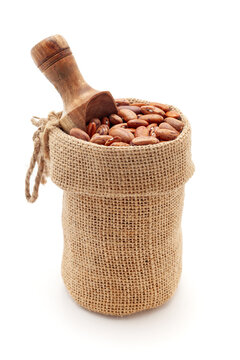 Close-up of Organic brown Kidney Beans or Rajma (Phaseolus vulgaris), in a jute bag with a scoop, Isolated on a white background.