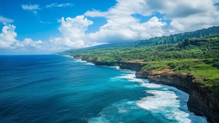 Fototapeta premium Amazing coastal landscape with steep cliffs overlooking the deep blue ocean, waves crashing against the rocks under a clear bright sky