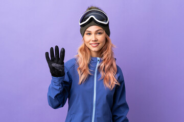 Skier teenager girl with snowboarding glasses over isolated purple background happy and counting four with fingers