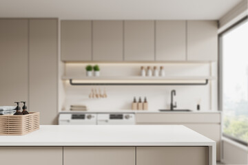 Beige laundry interior counter, washing machines and window, empty space