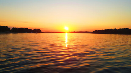 Fototapeta premium Stunning Sunset Over Calm Lake with Vibrant Orange and Yellow Sky Reflecting on Water