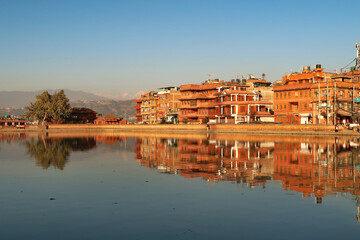 Golden hour at the Na Pukhu Lake, Pond in Bhaktapur, apartment, residential houses, buildings, dwellings are reflecting perfectly in the smooth surface of the water Bhaktapur, Nepal