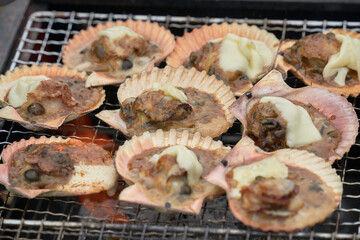 キャンプ場で料理された美味しそうなホタテ。バーベキューの写真