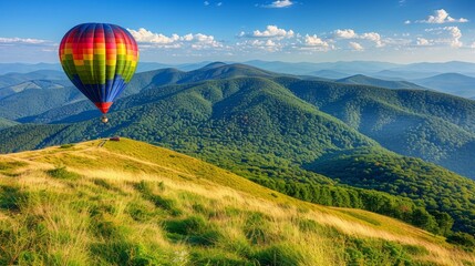 Fototapeta premium A serene hot air balloon ride over lush green mountains, offering breathtaking panoramic views. The clear blue sky and warm sun create a magical atmosphere, making it an unforgettable experience.