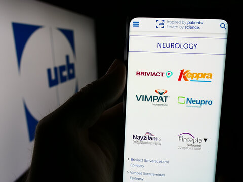 Stuttgart, Germany - 07-25-2024: Person holding smartphone with webpage of Belgian biopharmaceutical company UCB S.A. in front of logo. Focus on center of phone display.