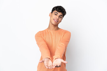 Obraz premium Young man over isolated white background holding copyspace imaginary on the palm to insert an ad