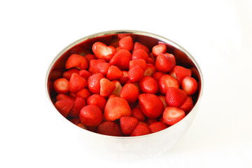 Red strawberries in stainless steel bowl on white background