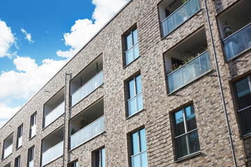 Luxurious apartments for sale. German architecture background. High block of flats living area. New build neighborhood modern style. Real estate market in Europe. Block of flats isolated on blue sky.