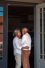 An Elderly Couple Embracing Each Other in the Doorway of Their Home, Filled with Love