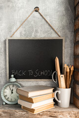 Time for school - blackboard, clock, books and school supplies on bricks background